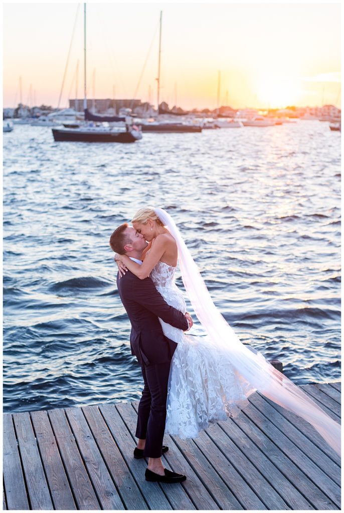 Bride and Groom kiss on the dock at the Bohlin Wedding Venue in Newport, RI at sunset