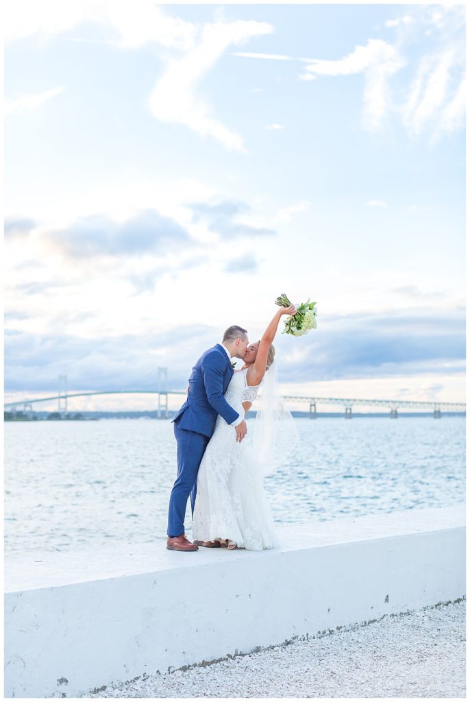 Bride and Groom kiss in front of the ocean view at Belle Mer Wedding in Rhode Island.