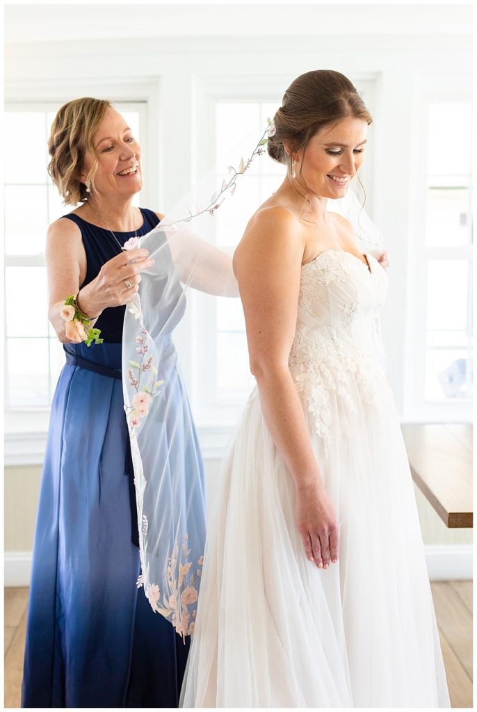A mom puts the veil on the bride at the spring House
