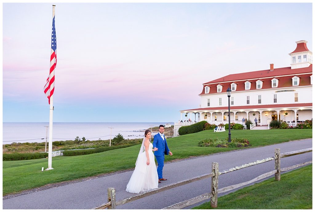 Bride and groom walk in front of the spring house with a colorful sunset.