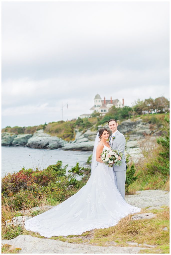 Bride and Groom smile on the cliffs of the lighthouse at Castle Hill Inn