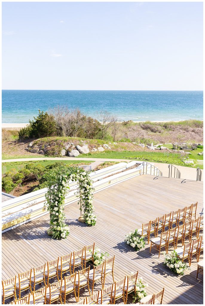 The ceremony space on the seaside veranda at the Ocean House decorated with white flowers for the wedding day. 
