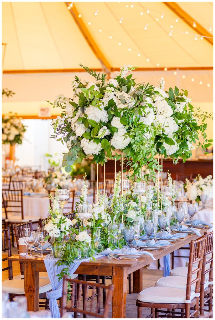 tall and lush reception table florals inside tent at The Bohlin wedding