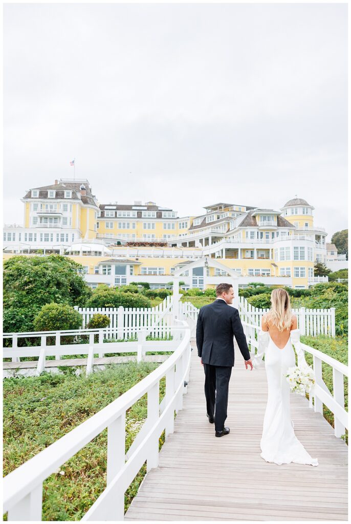Bride and groom walk to the Ocean House on the boardwalk. 