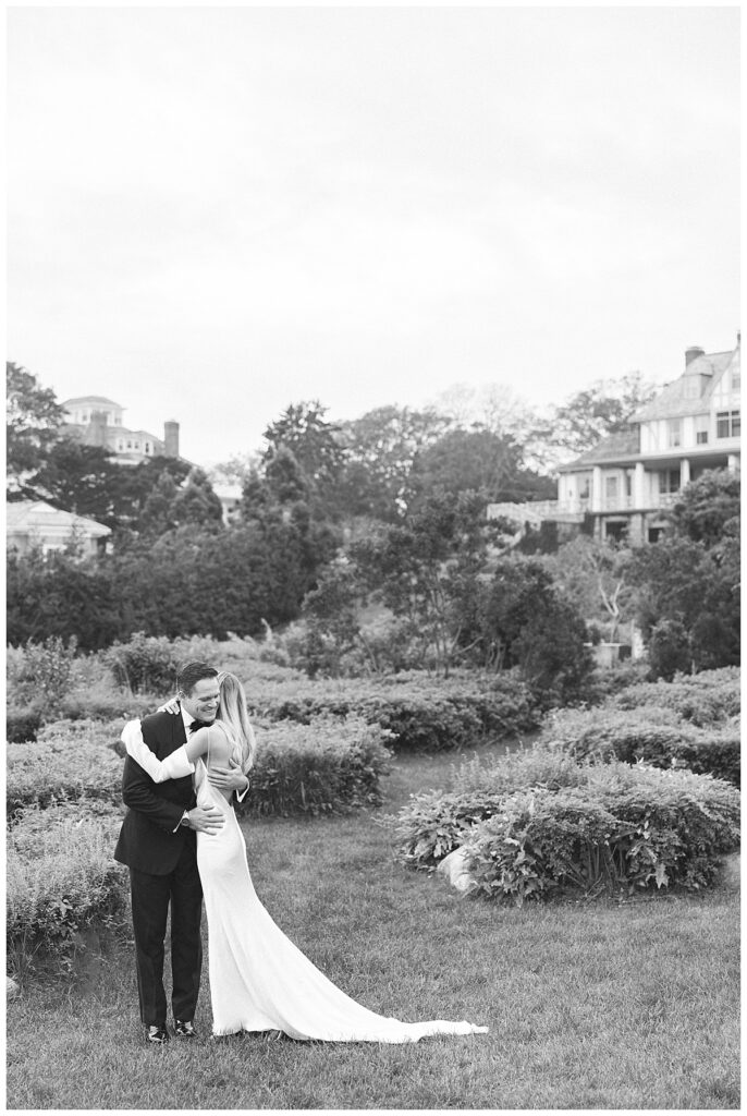 Bride and Groom hug in the herb garden at the Ocean House