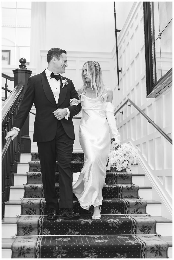 Bride and Groom walk down the staircase of the Ocean House.
