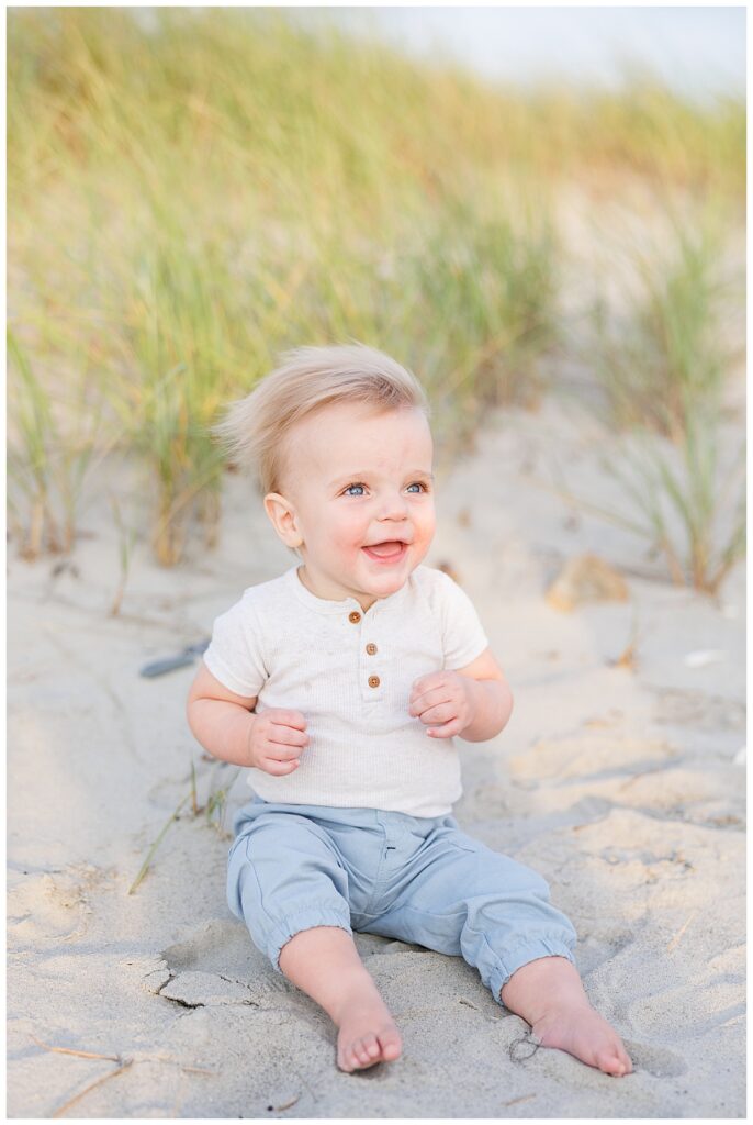 Portrait of baby smiling, sitting in the sand at Second Beach in Newport RI