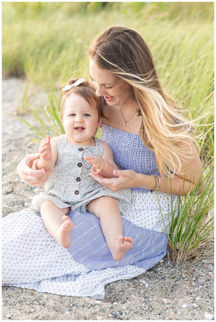 Mom and baby sitting on sand at Barrington Beach